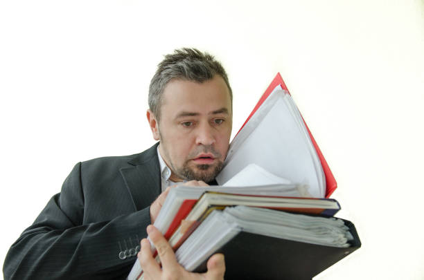 istock focused, serious businessman with folders in hand 643298058