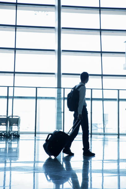 istock Businessman walking in airport corridor 643310356