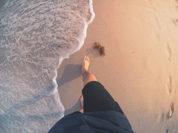POV: Walking Barefoot on a Beach Point of view shot of a man walking barefoot on a sunny beach in Florida. florida beach above stock pictures, royalty-free photos & images