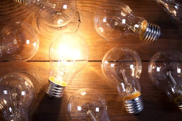 Vintage incandescent bulbs on old wooden table. This file is cleaned and retouched.