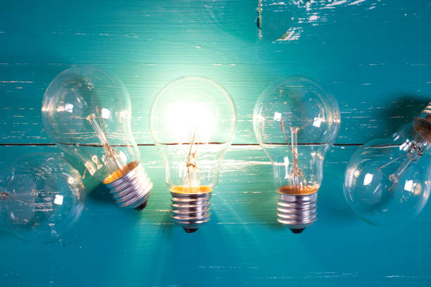 istock Vintage incandescent bulbs on turquoise wooden table 643317214