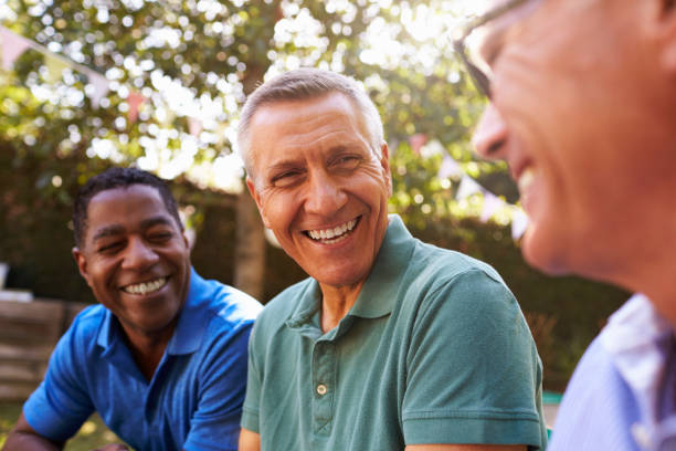 mature male friends socializing in backyard together - mature adult imagens e fotografias de stock