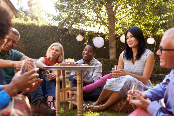 istock Group Of Mature Friends Enjoying Drinks In Backyard Together 643324902