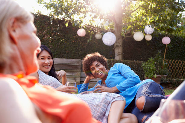istock Mature Female Friends Enjoying Drinks In Backyard Together 643324946