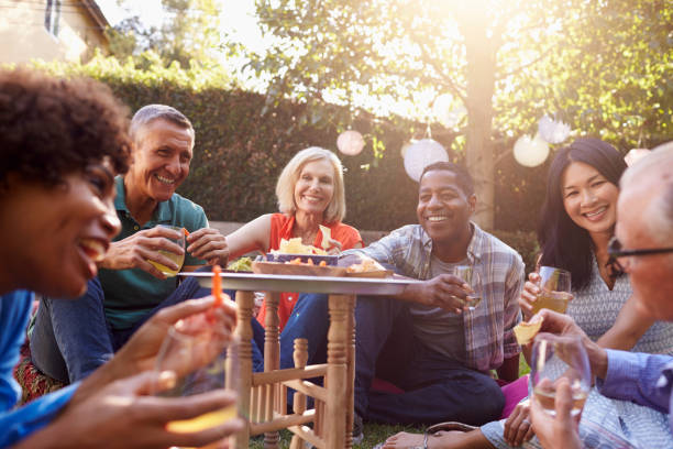 istock Group Of Mature Friends Enjoying Drinks In Backyard Together 643325076