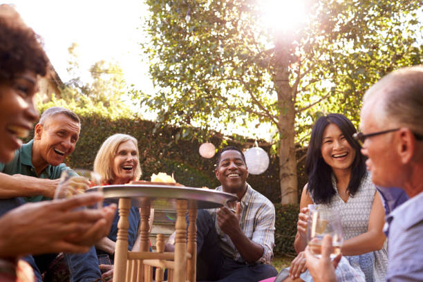 istock Group Of Mature Friends Enjoying Drinks In Backyard Together 643325260