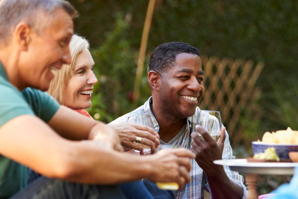 istock Group Of Mature Friends Enjoying Drinks In Backyard Together 643325280