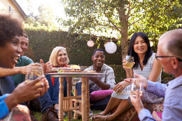 istock Group Of Mature Friends Enjoying Drinks In Backyard Together 643325306