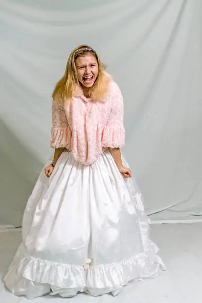 Screaming blonde fourteen year old in ballroom gown and jacket