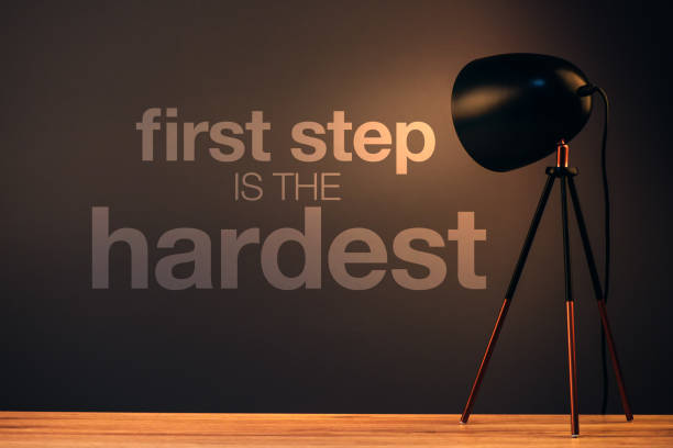 First step is the hardest, motivational message on office wall illuminated by the desk lamp