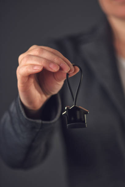 istock Female real estate agent with house model key ring 643336490