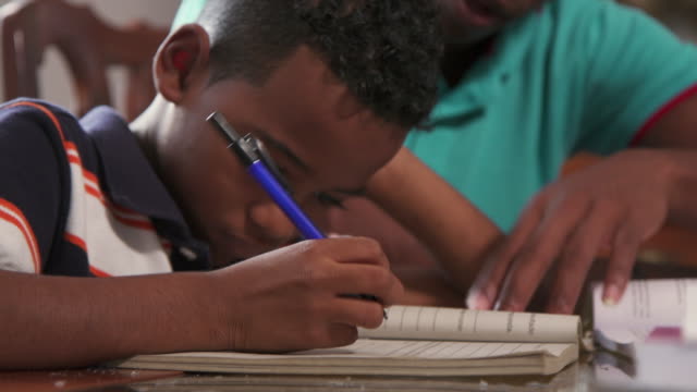 Boy Studying Education With Father Helping Son Doing School Homework