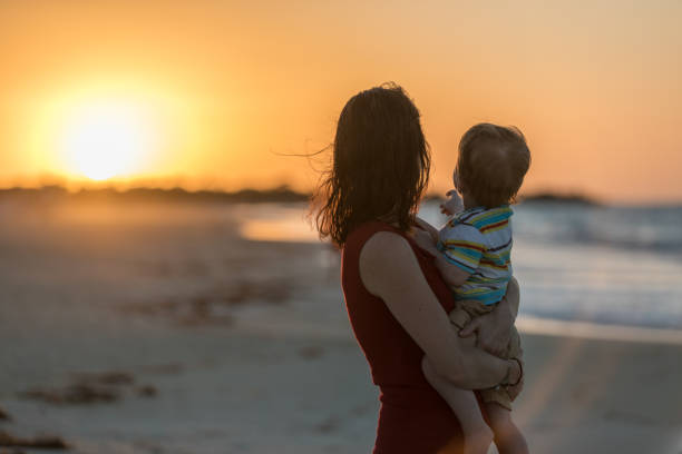 istock Mother Holding Baby Boy at Beach Sunset 643339210