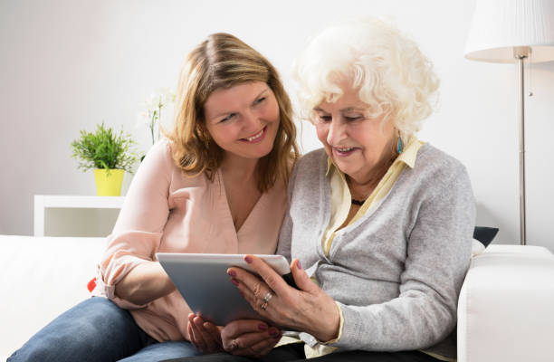 istock Grandaughter teaching grandmother how to use tablet 643343696