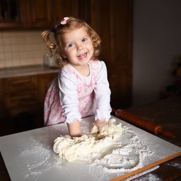 istock pretty little girl having fun kneads dough 643346710