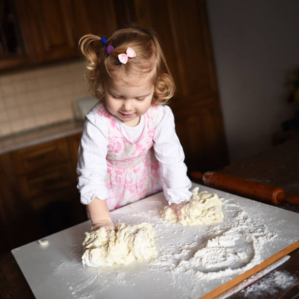 istock pretty little girl having fun kneads dough 643346758