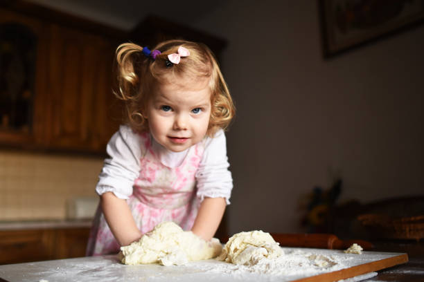 istock pretty little girl having fun kneads dough 643346970