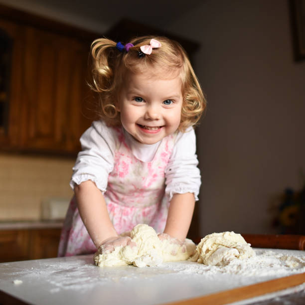 istock pretty little girl having fun kneads dough 643347034
