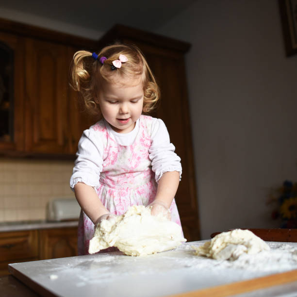 istock little girl kneading dough 643347132