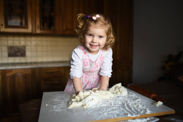 istock little girl kneading dough 643349258