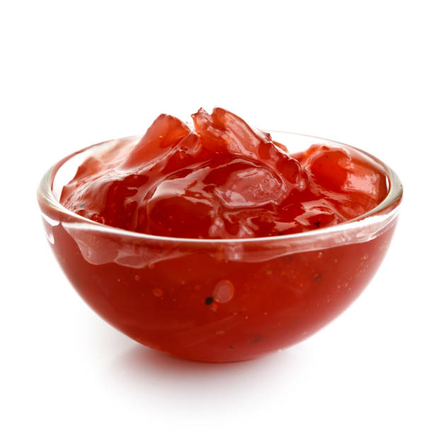 istock Red onion chutney in glass bowl isolated on white. 643354390