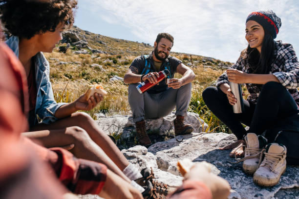 istock Group of hikers relaxing in field 643361304