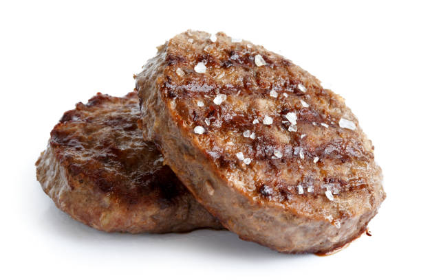 istock Two grilled hamburger patties with salt isolated on white. 643368222