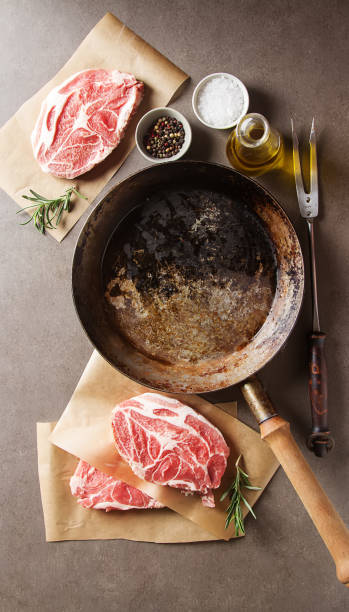 istock Raw pork steak - ready for cooking with herbs. Gray background. 643372674