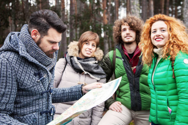 istock Group of friend into wood watching map 643389962