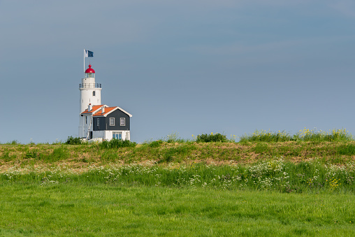 Lighthouse standing out above a dyke at the island of Marken in the Netherlands.
