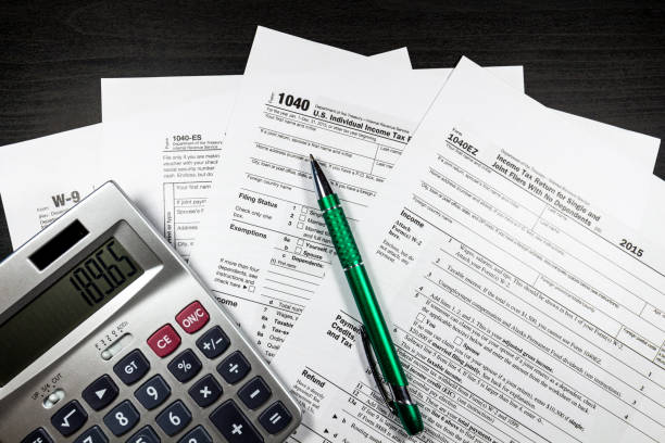 istock 1040 and W-9 Forms with pen and calculator 643424682