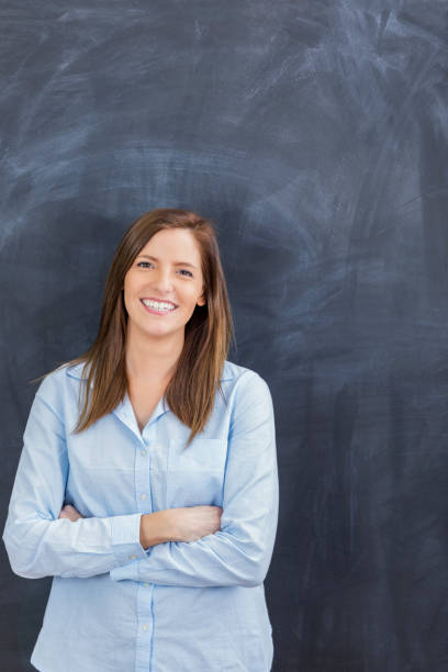 istock Beautiful high school teacher in front of blackboard 643428572
