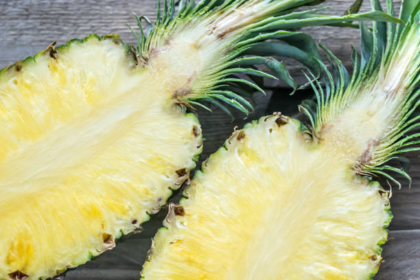 istock Pineapple on the wooden background: cross section 643442456