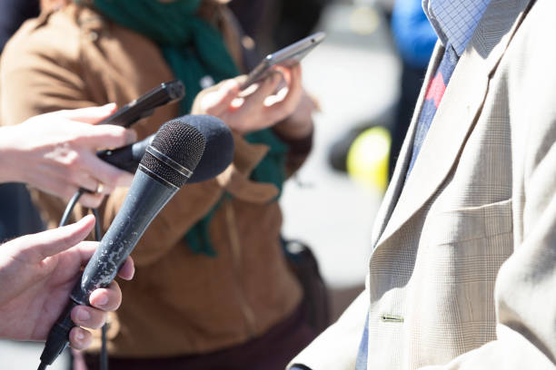 istock Journalist holding a microphone conducting an TV or radio interview 643456542