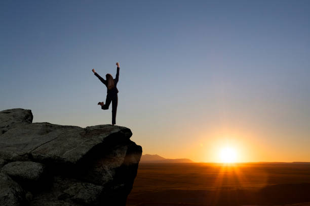 istock Businesswoman With Arms Extended On Mountaintop 643456874