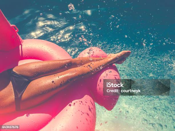 Woman Floating On A Pink Inflatable In Swimming Pool Stock Photo - Download Image Now