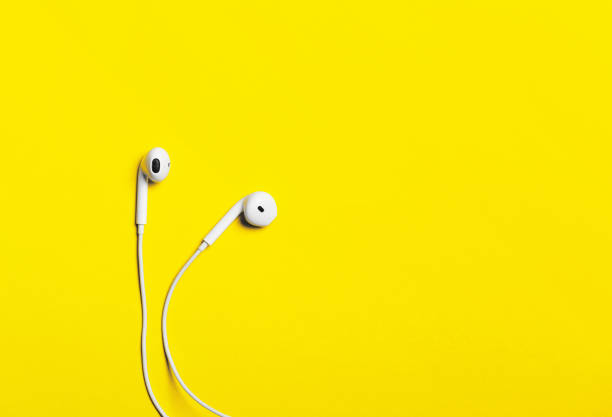 istock White headphones on a yellow paper background. 643465812