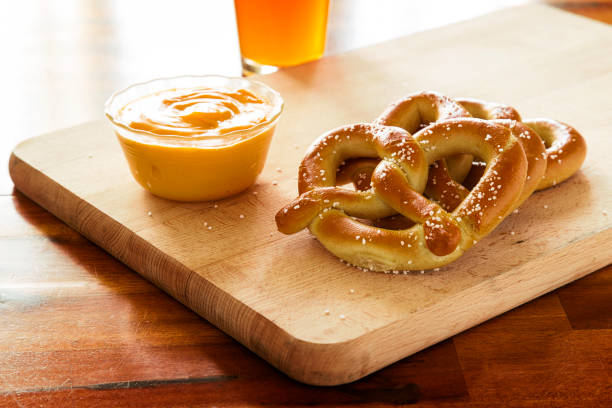 Pretzels and Cheese pretzels and dipping cheese on wood cutting board with beer pretzel photos stock pictures, royalty-free photos & images