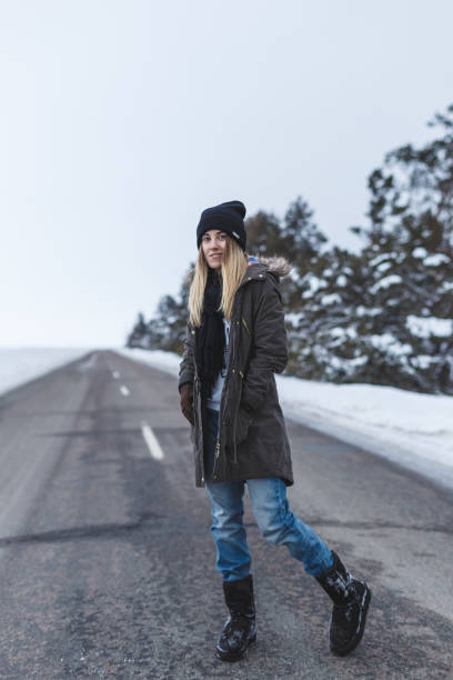 istock Girl is standing on the winter road 643469782