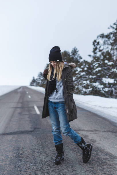 istock Girl is standing on the winter road 643469820