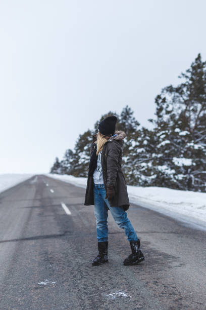 Girl is standing on the winter road
