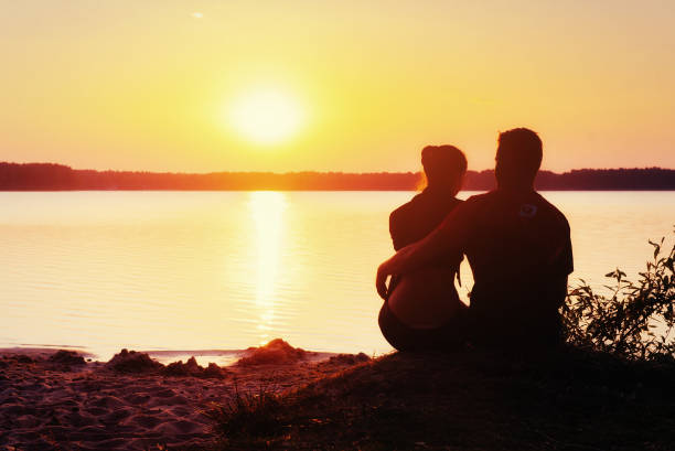 istock Romantic couple on the beach at colorful sunset  background 643472540