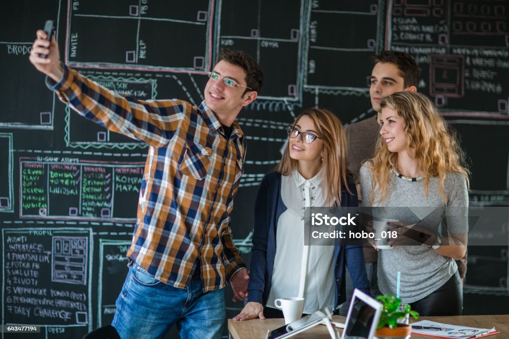 Business people taking selfie of themselves in the office Group of creative business people in the office, taking selfie and have a fun Graphic Design Studio Stock Photo