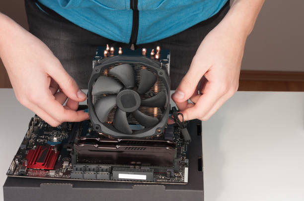 istock Young man installing CPU cooler fan on  motherboard 643484312