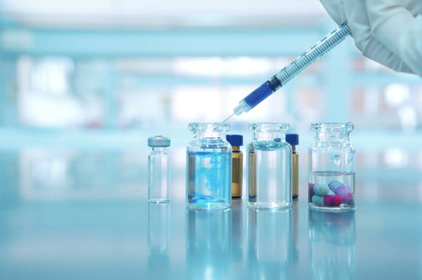 istock hand with syringe vial and capsule pill on science laboratory 643484754