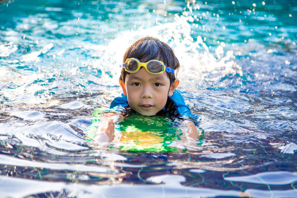 istock boy learn to swim in the swimming pool 643508958