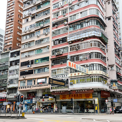 Hong Kong, China - November 26, 2016: A typical, chaotic, busy, street scene found in Hong Hong. There are plenty of colorful signs, many pedestrians going about their day, and continuous vehicular traffic creating a constant buzz of noise.