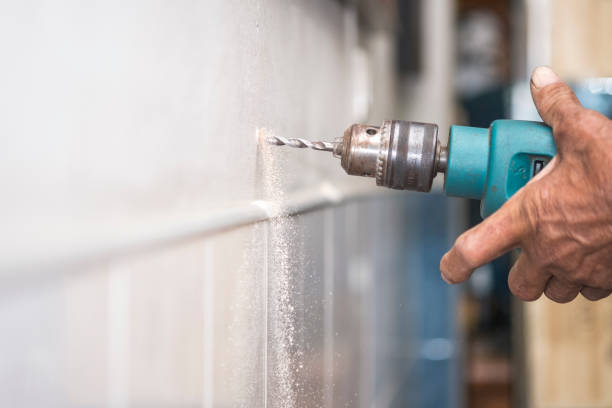 istock hands hold electric drill in room 643534936