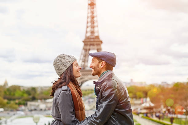 Young and in love in Paris Shot of a happy young couple kissing together in front of the Eiffel Tower paris france eiffel tower love kissing stock pictures, royalty-free photos & images