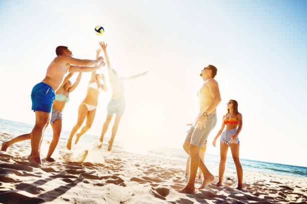 istock Friends playing beach voleyball sunset time 643544014